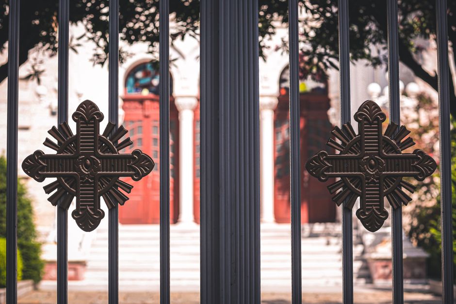 An iron gate hung between two posts at a yard entrance.