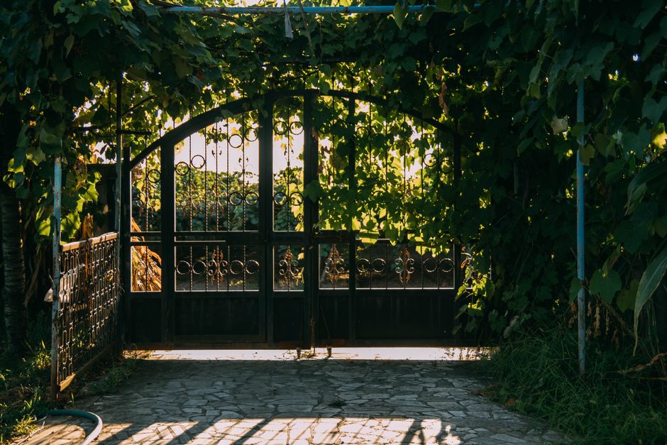 A swing gate with picket infill and a sturdy frame.