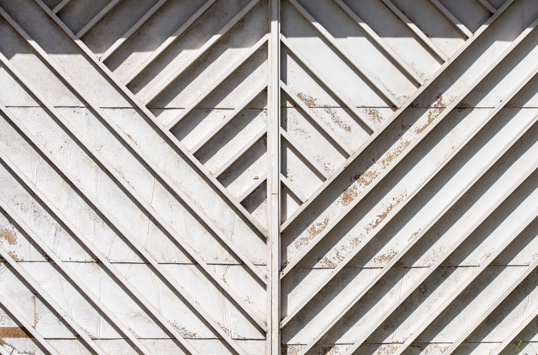 Close-up view of a weathered metal gate with geometric patterns and diagonal lines in Austin, TX