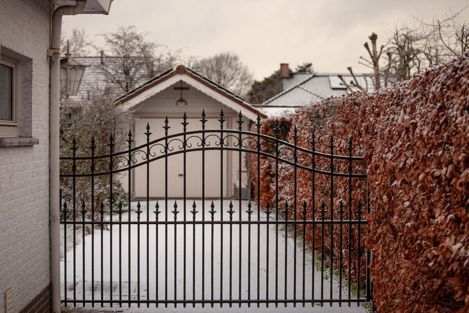 A wrought iron style gate closed across an opening in a fence.